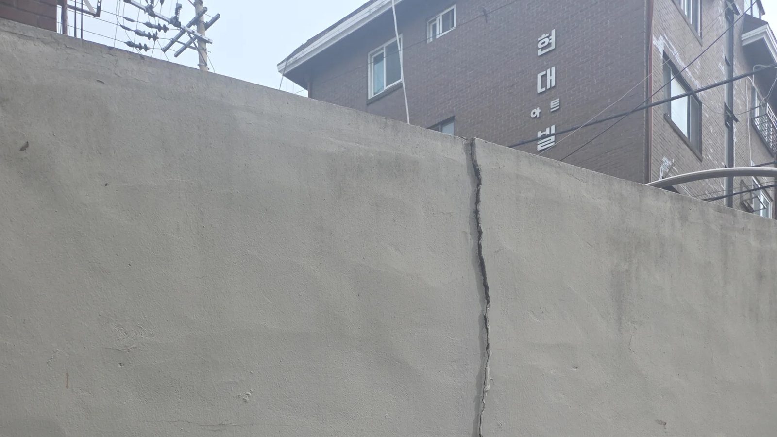 담장 너머로 이웃 건물이 보이는 은평구 담장 상단 균열